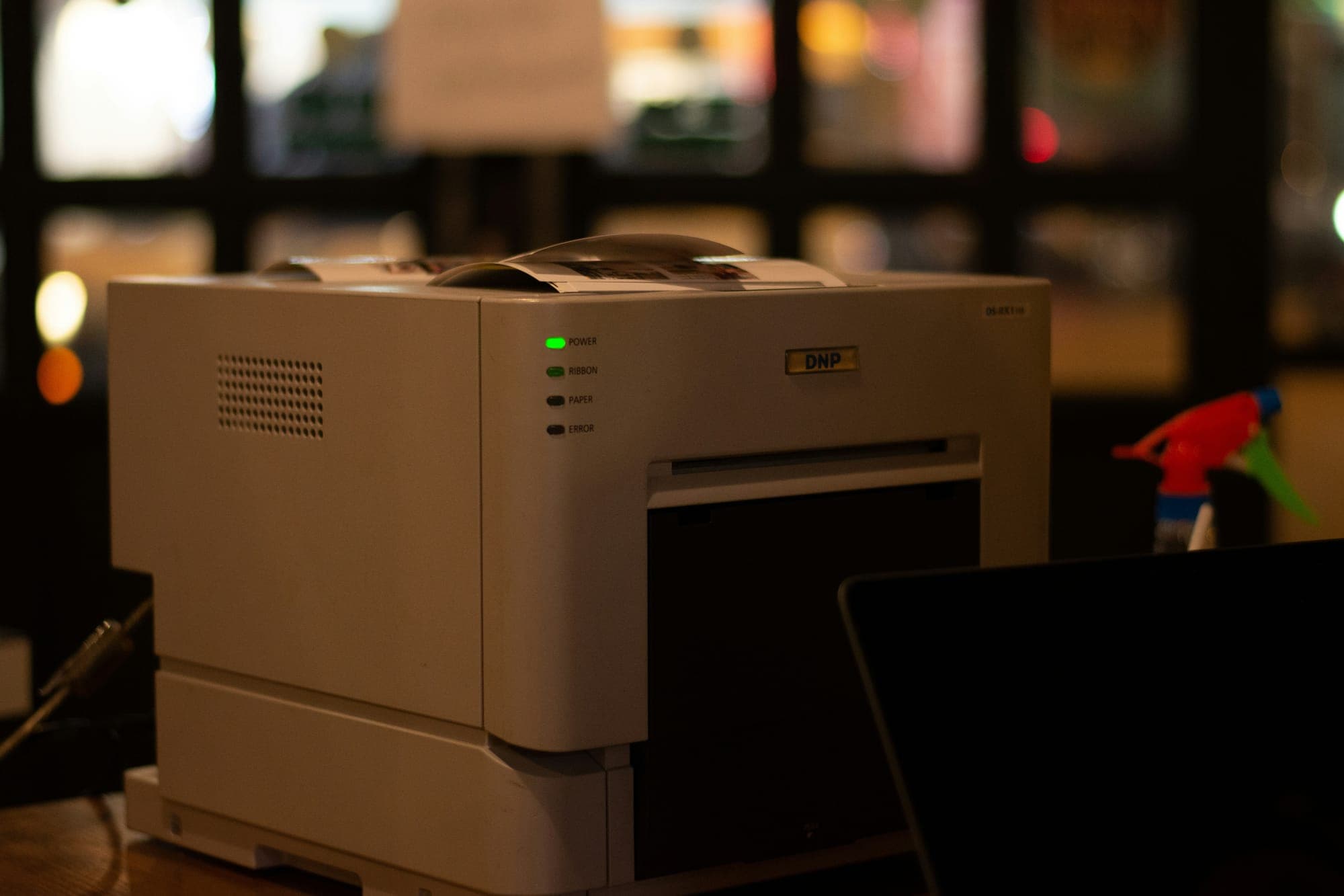 Pantum printing solutions — professional photo printer with status lights in a dark studio
